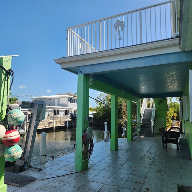 view of patio / terrace featuring stairway, a water view, and a boat dock