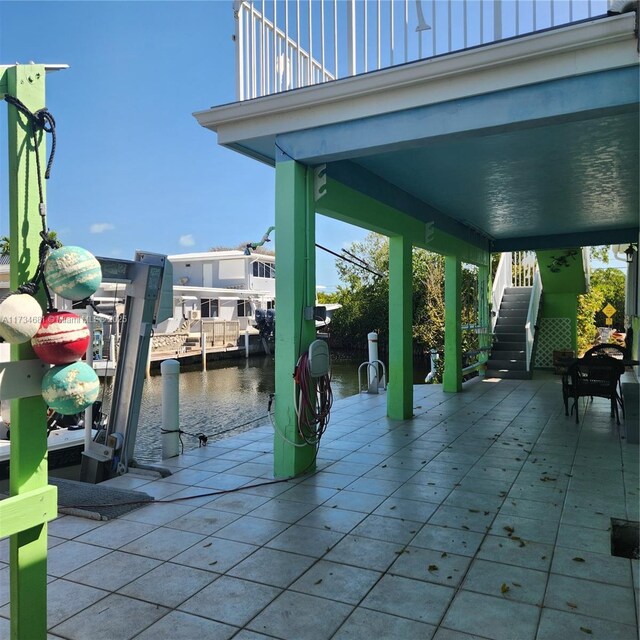 view of patio / terrace featuring stairs, a water view, and a boat dock