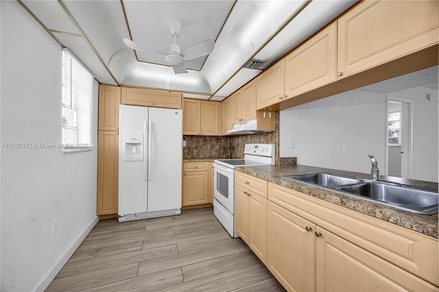 kitchen featuring white appliances, light brown cabinetry, sink, and backsplash