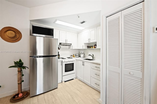 kitchen featuring stainless steel appliances, sink, white cabinets, and light hardwood / wood-style floors