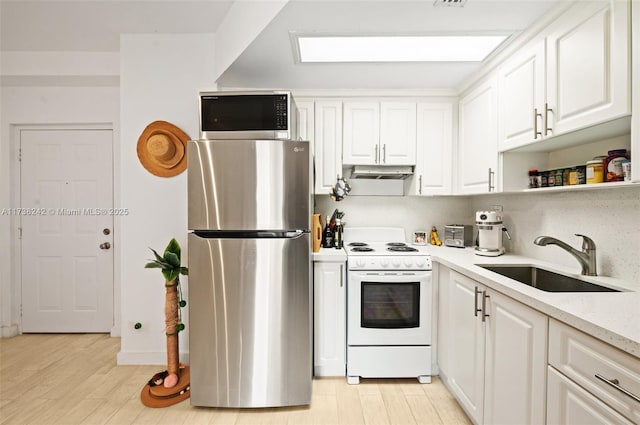 kitchen with light stone countertops, appliances with stainless steel finishes, sink, and white cabinets