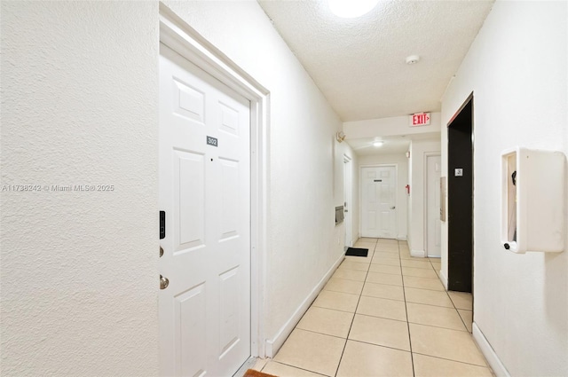 hallway with light tile patterned flooring and a textured ceiling