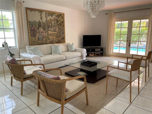 living room featuring an inviting chandelier, light tile patterned floors, and french doors