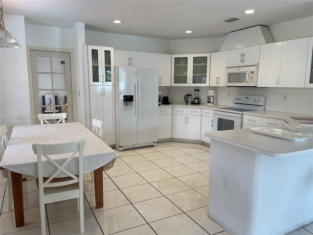 kitchen with white cabinetry, white appliances, a breakfast bar, and light tile patterned flooring