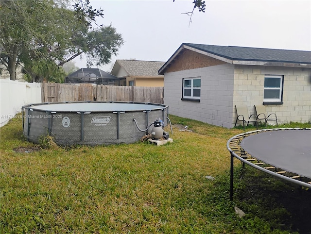 view of yard featuring a fenced in pool and a trampoline