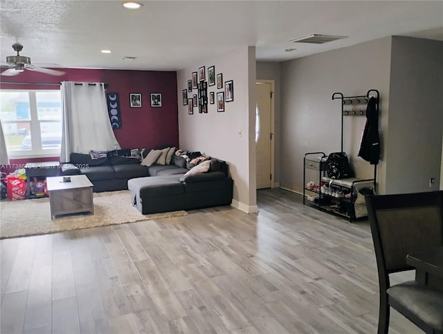 living room with light hardwood / wood-style floors and ceiling fan