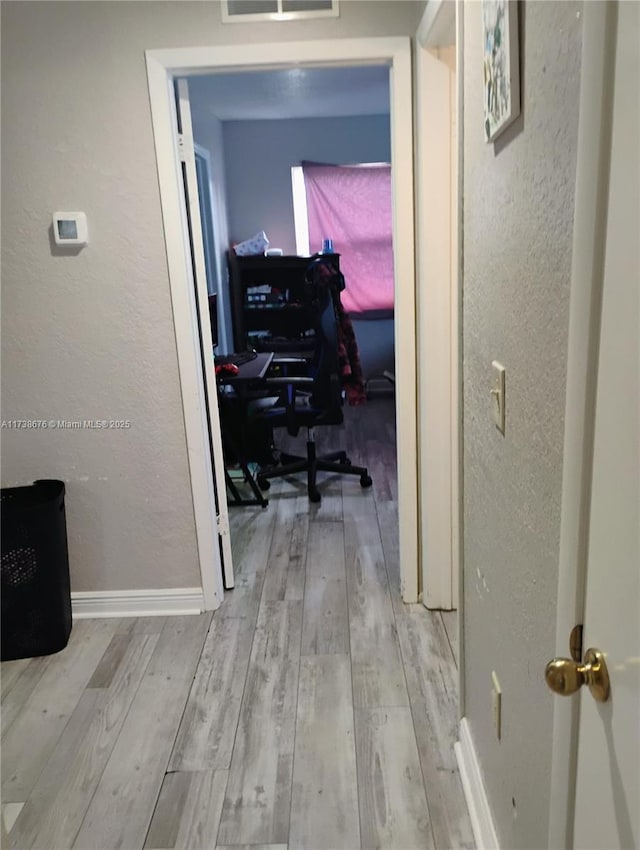 corridor with light hardwood / wood-style floors