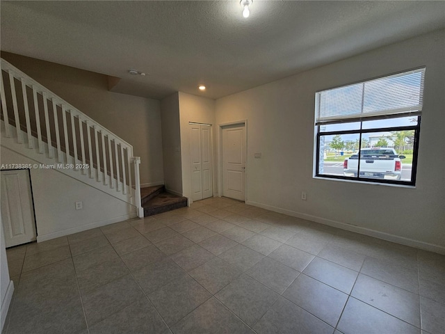 tiled foyer entrance featuring a textured ceiling