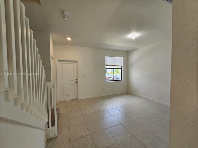 interior space featuring a textured ceiling and light tile patterned floors