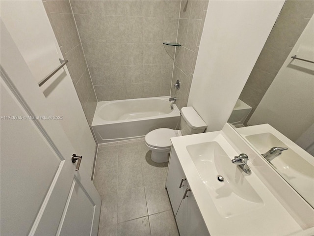 full bathroom with tile patterned flooring, tiled shower / bath, vanity, and toilet