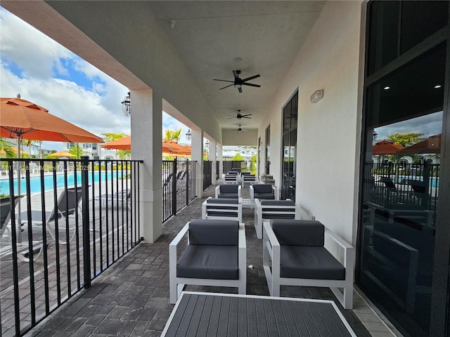 view of patio / terrace with ceiling fan and a community pool