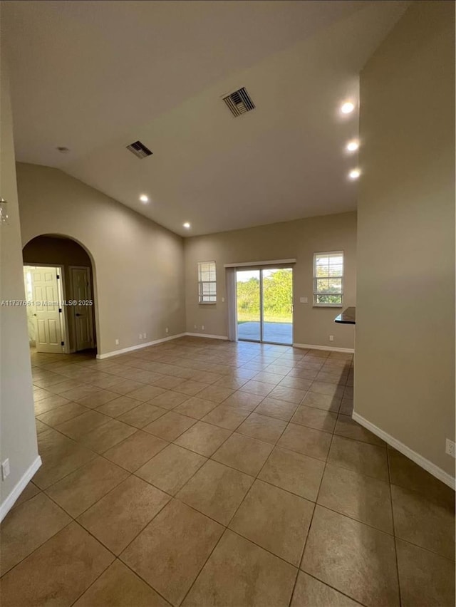 spare room featuring light tile patterned flooring and vaulted ceiling