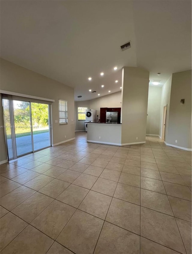 unfurnished living room featuring a wealth of natural light, washer / dryer, and light tile patterned floors