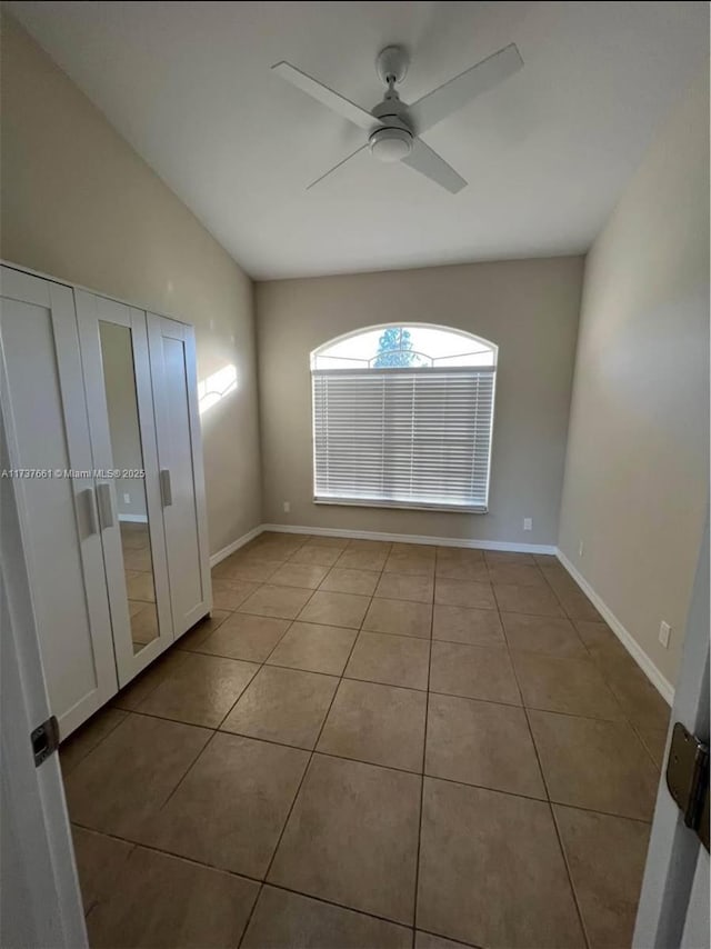 tiled spare room with ceiling fan and lofted ceiling