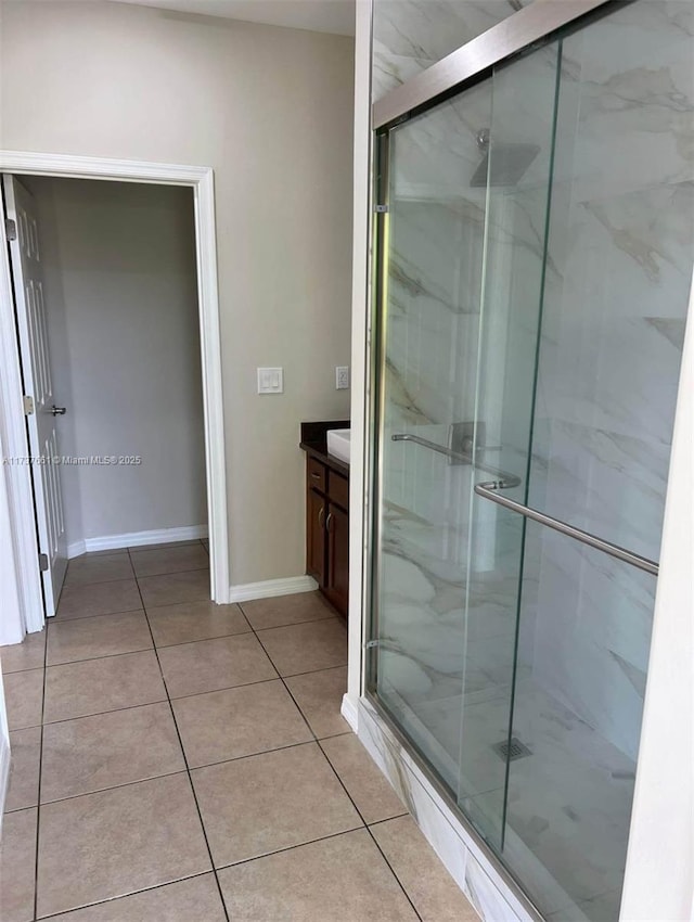 bathroom featuring tile patterned flooring, vanity, and walk in shower