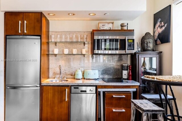 kitchen with appliances with stainless steel finishes, sink, and backsplash