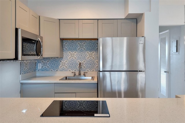 kitchen featuring tasteful backsplash, sink, gray cabinets, and appliances with stainless steel finishes