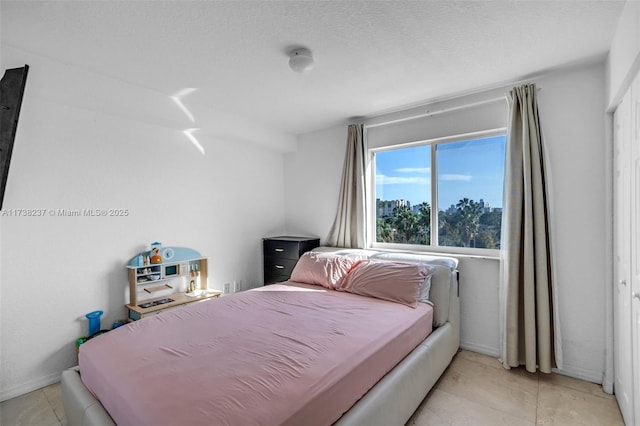 tiled bedroom with a textured ceiling