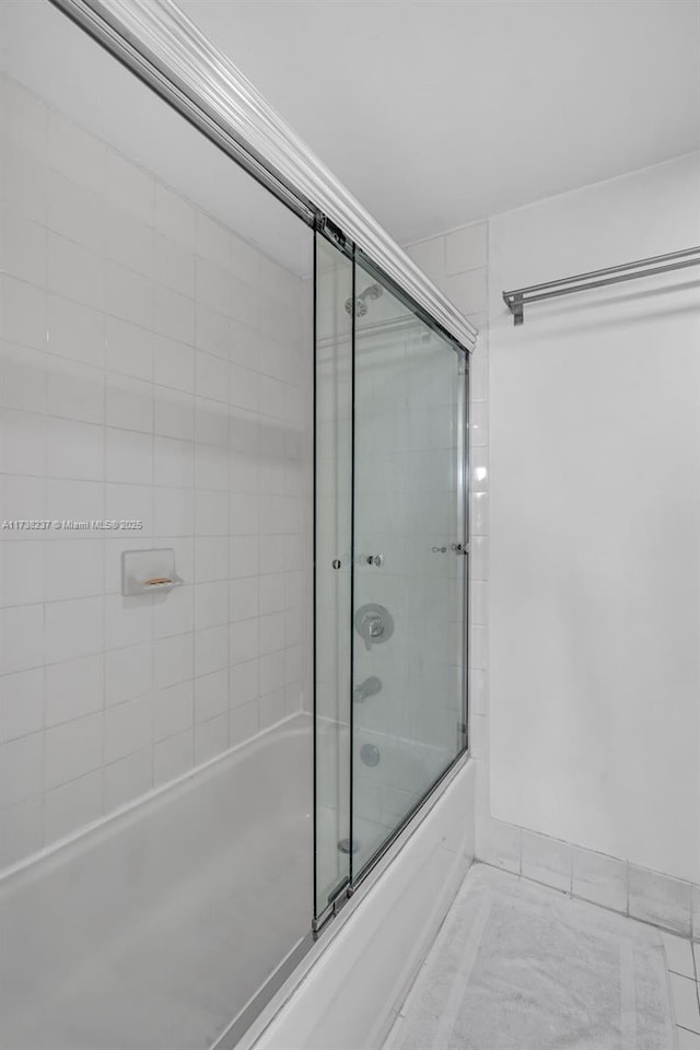 bathroom with bath / shower combo with glass door