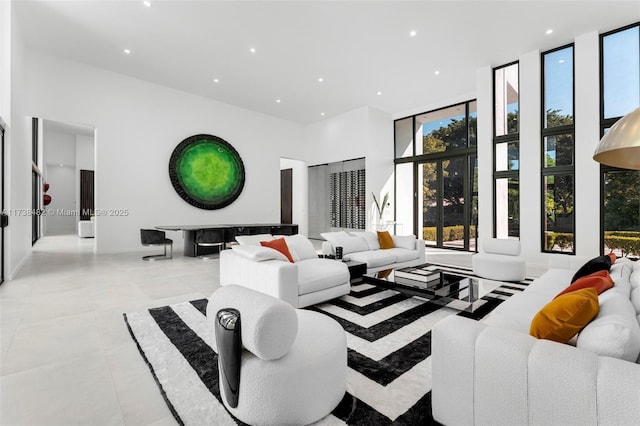 tiled living room with floor to ceiling windows and a high ceiling