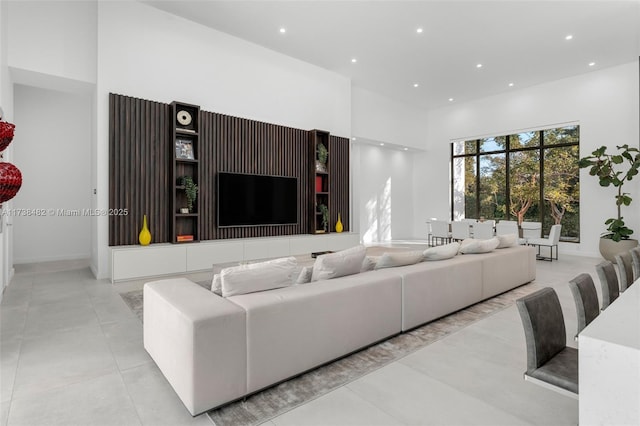 living room featuring light tile patterned flooring and a high ceiling