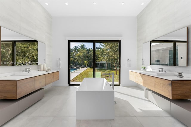 bathroom with tile patterned flooring, vanity, a towering ceiling, and separate shower and tub