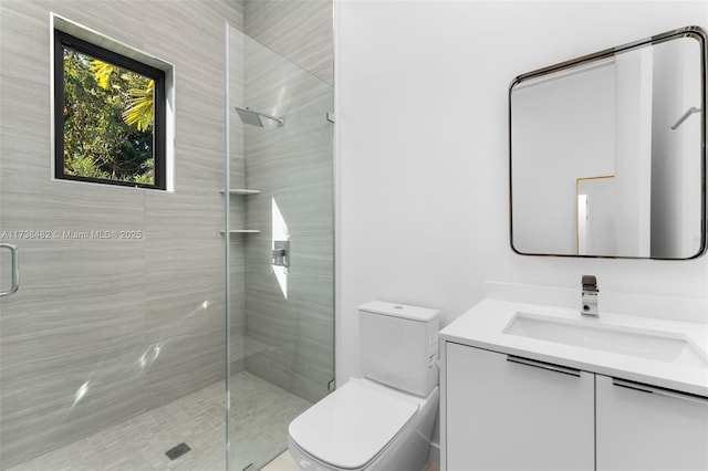 bathroom featuring vanity, a shower with shower door, and toilet