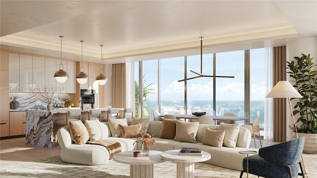 living room featuring light hardwood / wood-style flooring, a wall of windows, a raised ceiling, and a chandelier