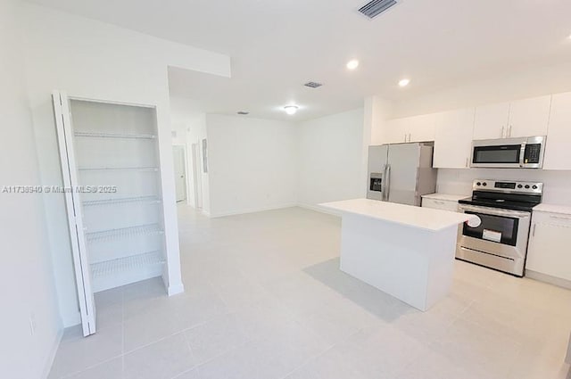 kitchen featuring appliances with stainless steel finishes, a kitchen island, and white cabinets