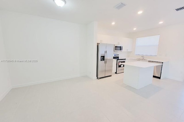 kitchen featuring a kitchen island, white cabinetry, appliances with stainless steel finishes, and sink