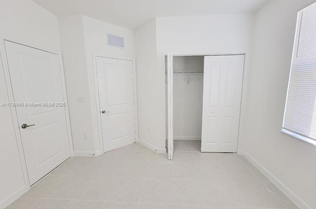 unfurnished bedroom featuring light tile patterned floors and a closet