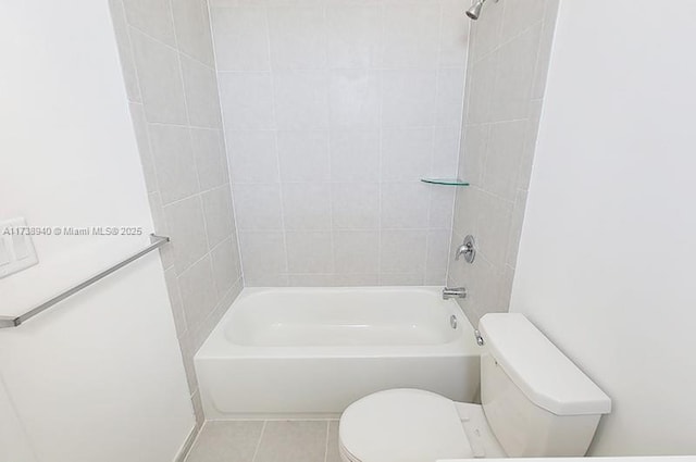 bathroom with tile patterned flooring, tiled shower / bath combo, and toilet