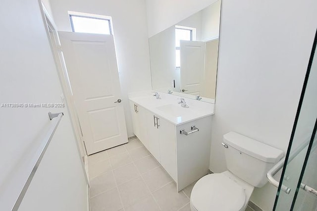 bathroom featuring vanity, toilet, a shower with shower door, and tile patterned flooring