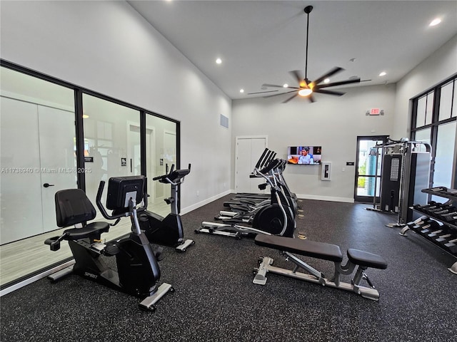 workout area featuring ceiling fan and a high ceiling