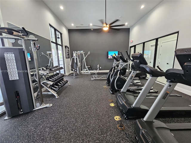 workout area with a towering ceiling and ceiling fan