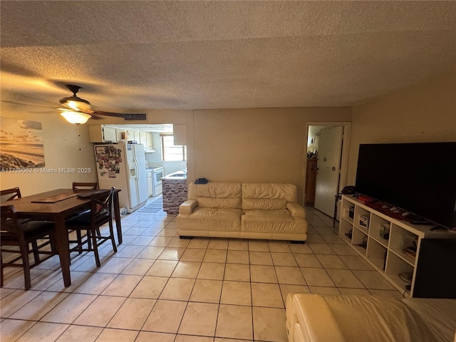 tiled living room with ceiling fan and a textured ceiling