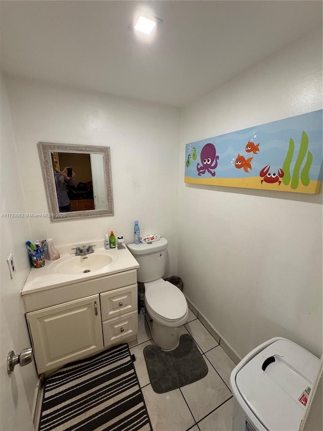 bathroom with tile patterned flooring, vanity, and toilet