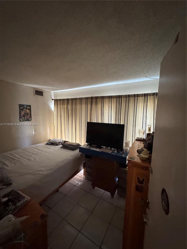 bedroom featuring light tile patterned floors and a textured ceiling