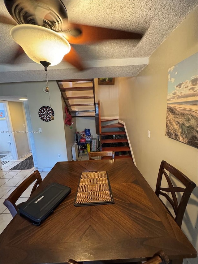 tiled dining space with a textured ceiling