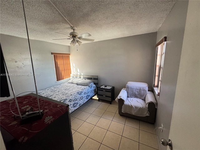 tiled bedroom featuring a textured ceiling and ceiling fan