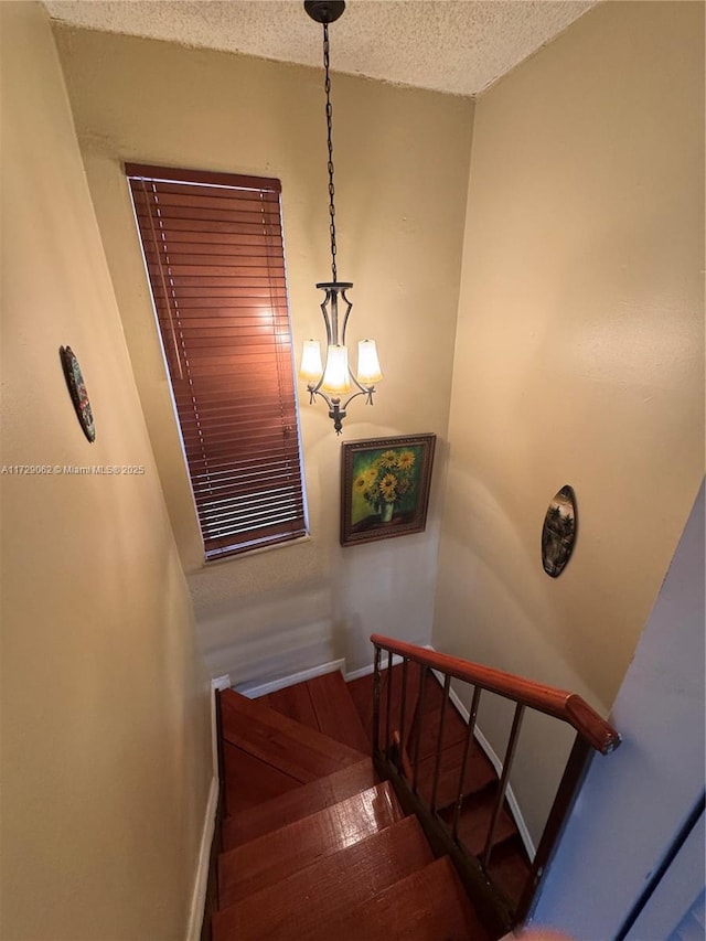 staircase featuring hardwood / wood-style flooring and a textured ceiling