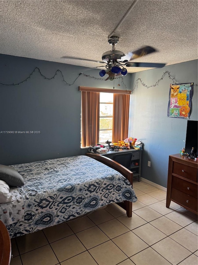 bedroom with ceiling fan, light tile patterned flooring, and a textured ceiling