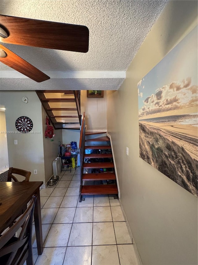 stairway with tile patterned floors and a textured ceiling