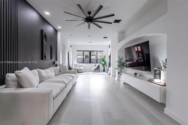 living room featuring ceiling fan and light hardwood / wood-style flooring