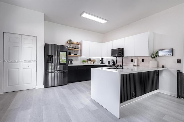 kitchen featuring stainless steel fridge with ice dispenser, decorative backsplash, kitchen peninsula, and white cabinets