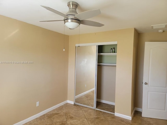 unfurnished bedroom with light tile patterned flooring, ceiling fan, and a closet