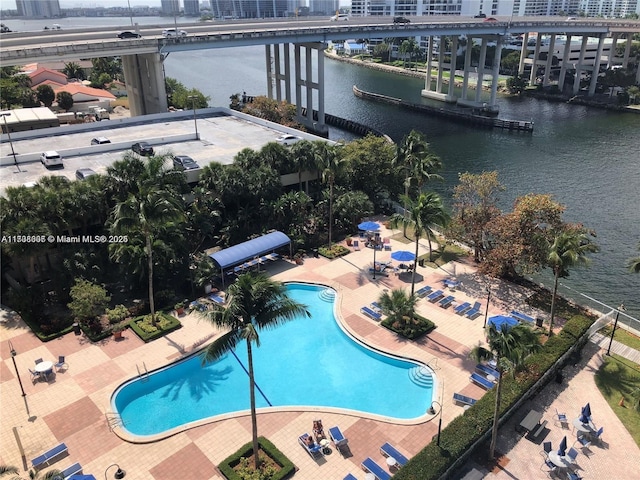 view of swimming pool featuring a water view and a patio area