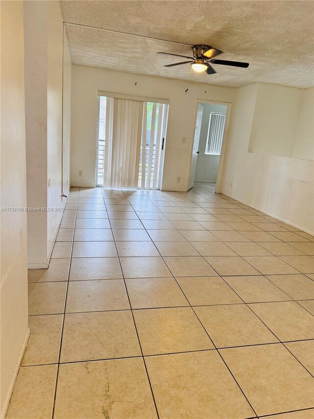 unfurnished room with light tile patterned floors, a textured ceiling, and ceiling fan