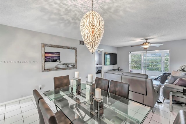 dining room with light tile patterned flooring, ceiling fan with notable chandelier, and a textured ceiling