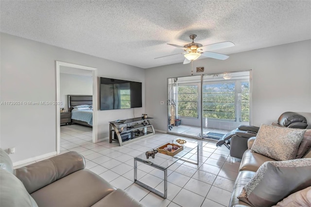 living room featuring light tile patterned flooring, ceiling fan, and a textured ceiling